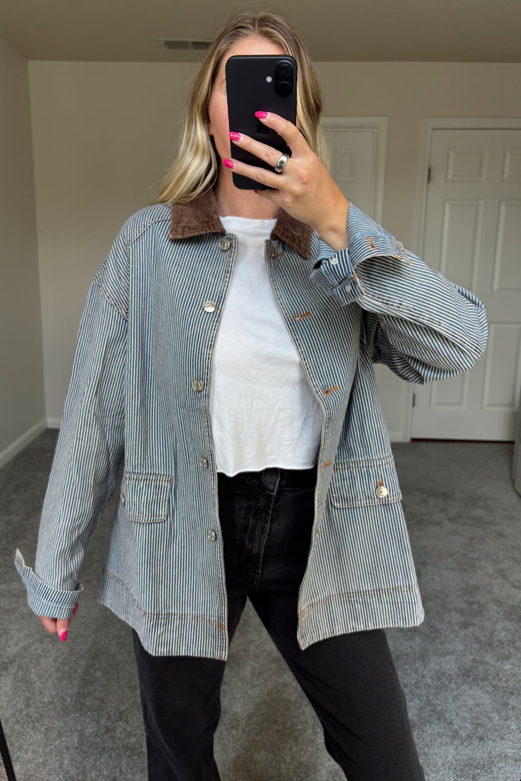 Derby striped denim barn jacket worn open, showing its relaxed shape and two front flap pockets over black jeans.

