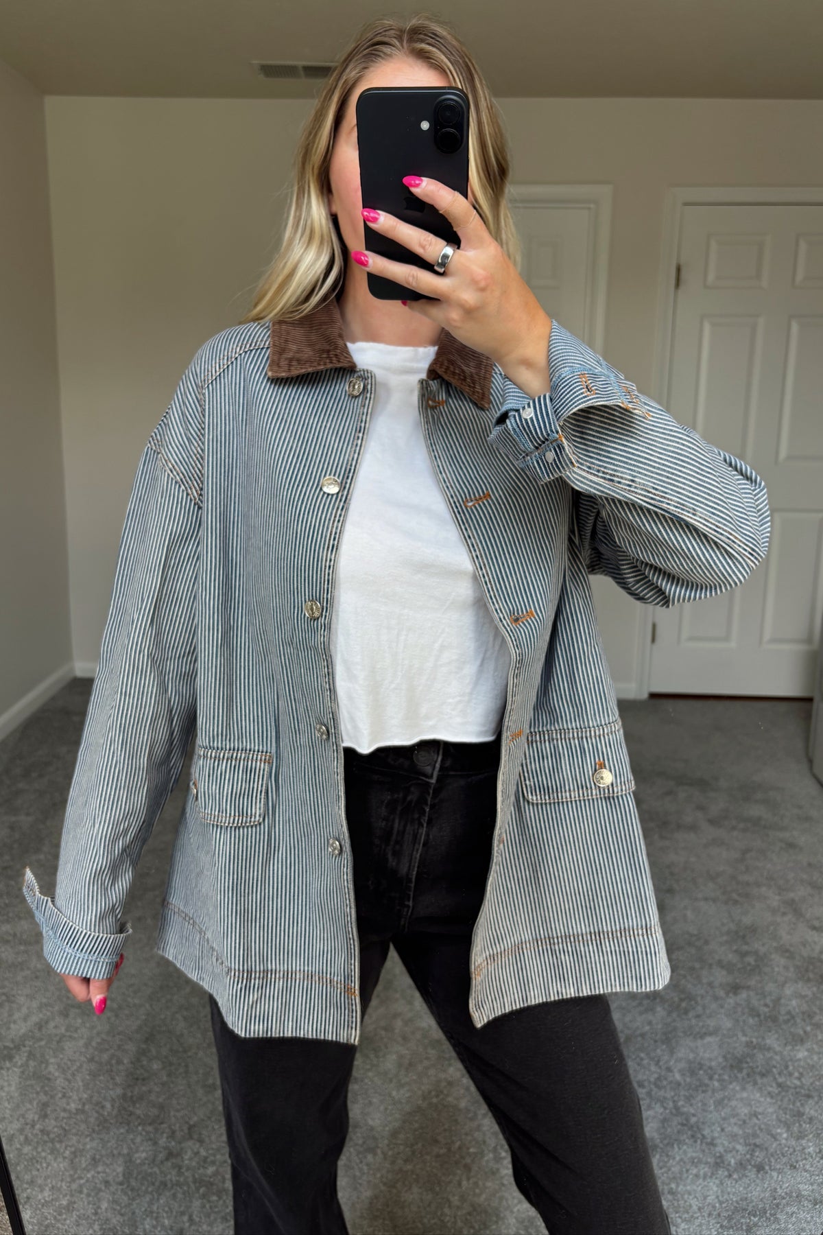 Derby striped denim barn jacket worn open, showing its relaxed shape and two front flap pockets over black jeans.

