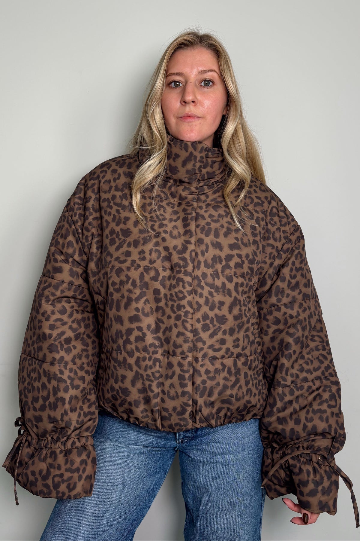 Front view of a model in the Coco Leopard Puffer Jacket zipped up, showing the leopard print and high stand collar