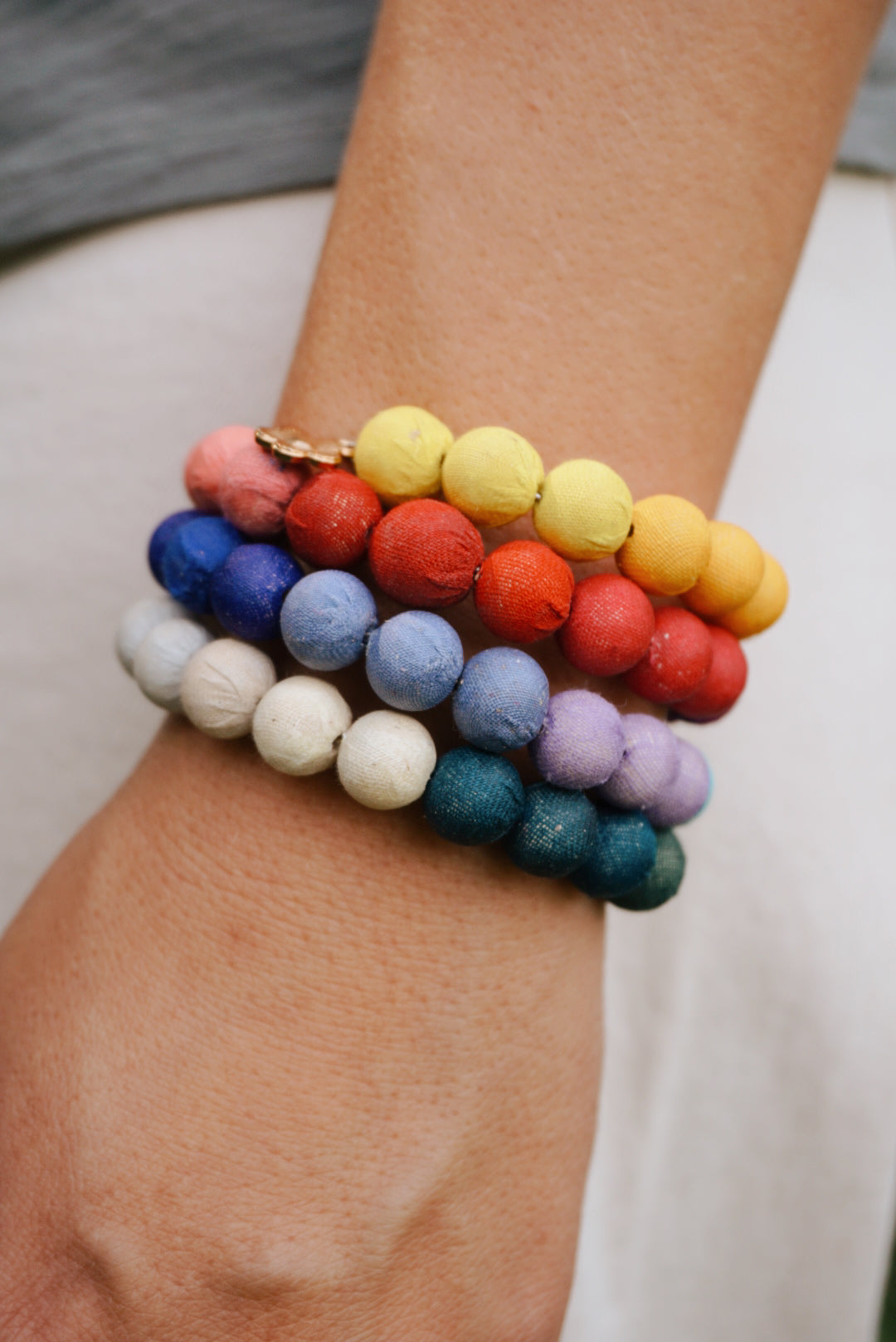 Person wearing a ivory oversized shirt and blue jeans against a plain background