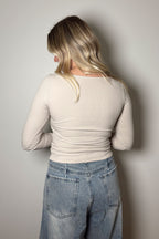 Back view of the Onyx bone ribbed top showing its fitted shape and straight hem above light-wash jeans.

