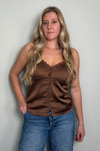 Front view of a model in the Delancey brown polka dot cami with delicate lace trim, button-front detail, and adjustable straps