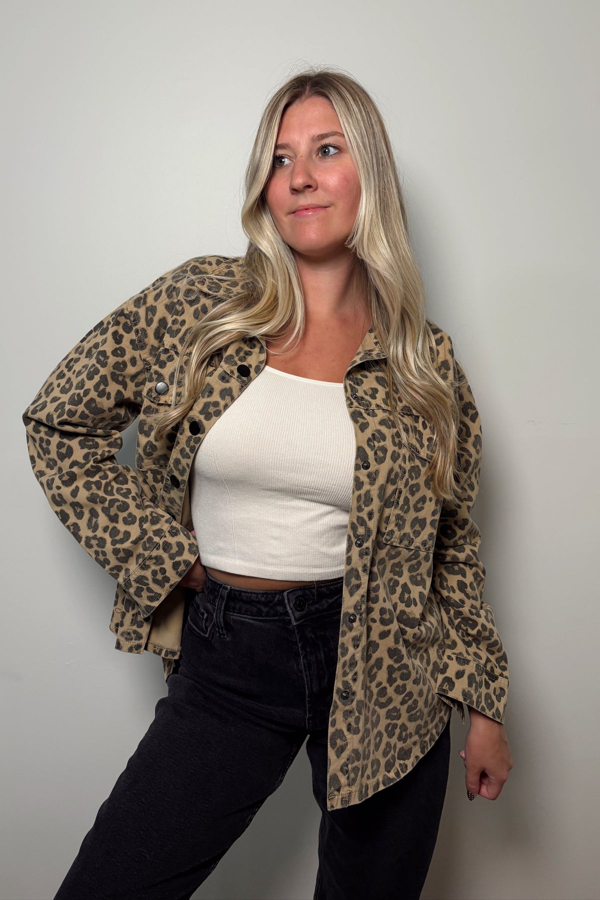 Angled front view of the Wild Muse leopard print shacket worn open, showing its relaxed fit and button-cuff sleeves.

