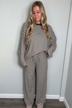 Model in the grey and cream Blair striped lounge set looking down with a gentle smile, one hand in her pocket, drawstring tie waistband visible