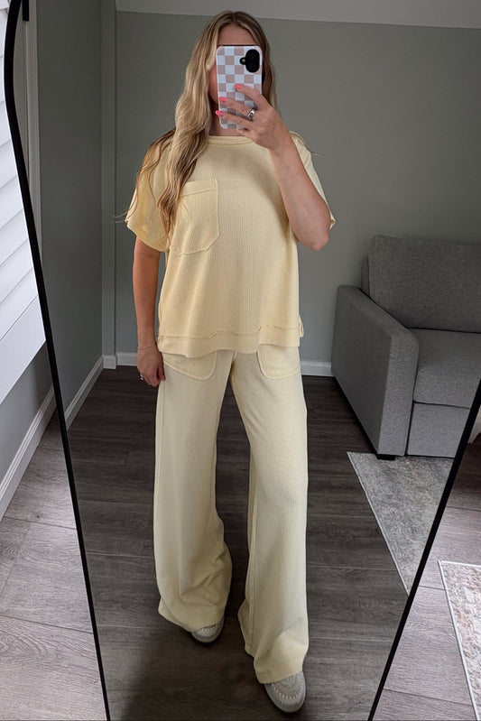 Person wearing a yellow top and pants standing in front of a mirror.
