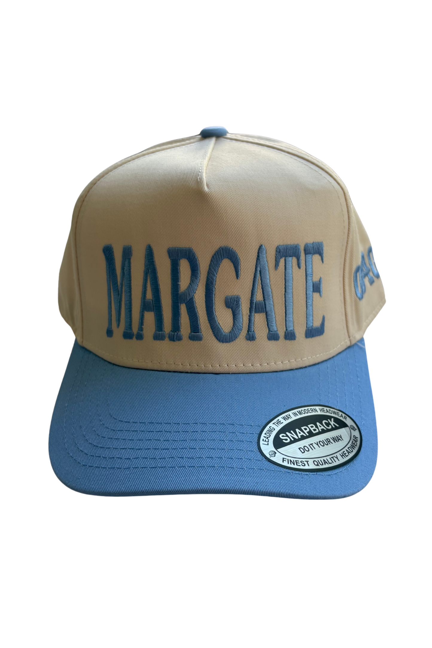 A beige and blue trucker-style cap with 'MARGATE' embroidered in blue on the front panel and a blue brim. A circular 'SnipLoc' brand sticker is visible on the brim.