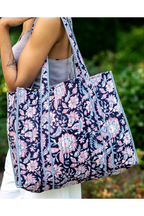 Woman carrying the Midnight Desert navy floral quilted tote bag over her shoulder outdoors